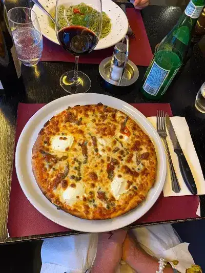 Eine Pizza auf einem Teller, frisch gebacken und mit verschiedenen Belägen belegt.