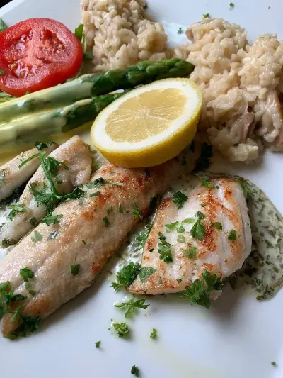 Ein Teller mit Fisch, Spargel und Reis, appetitlich angerichtet.